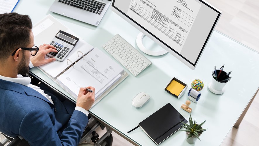 Expert-comptable établissant une facture au bureau